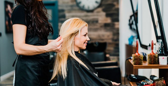hairdresser evaluating blonde hair for re-dyeing