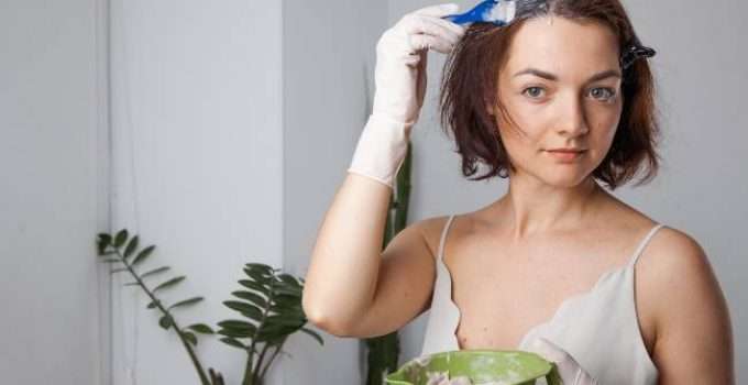 muchacha se aplica tinte en el cabello
