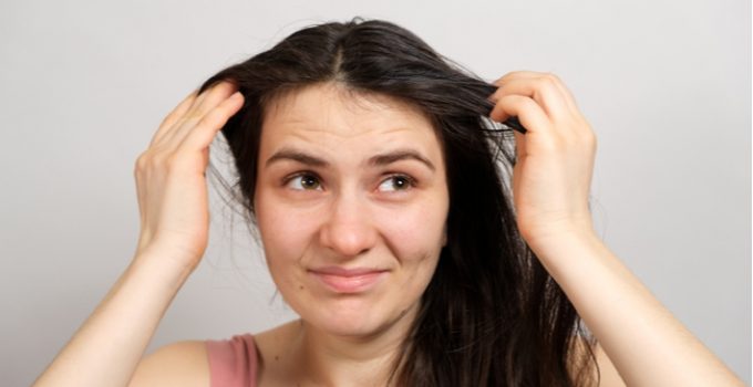 woman touching her greasy hair
