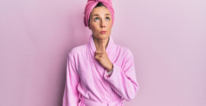 mujer piensa envuelta en bata de baño