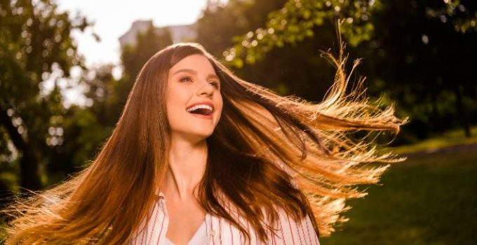 Chica con cabello castaño bajo el sol