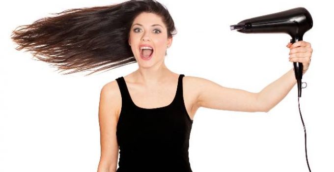 Mujer contenta seca su cabello con secadora