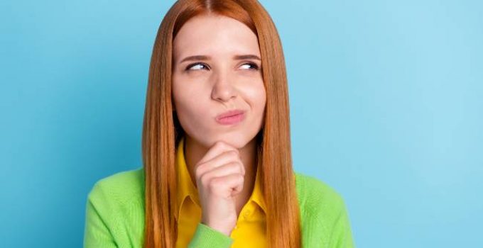 mujer pelirroja con cabello liso dudando