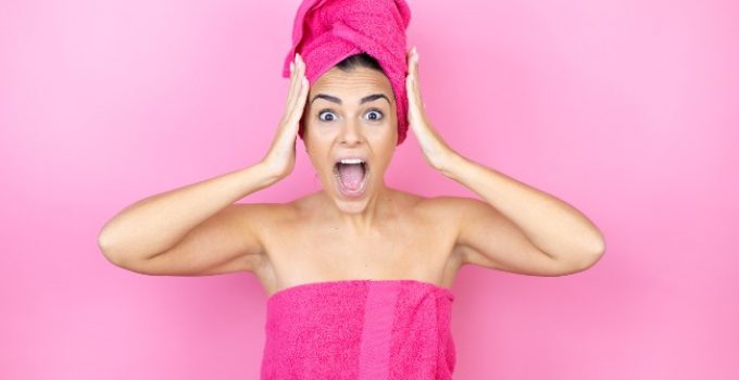mujer asustada con pelo envuelto en toalla