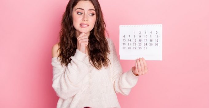 joven bonita con calendario en la mano