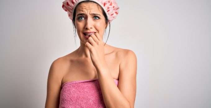 mujer con dudas después de cubrir su pelo con gorra de ducha después de teñirlo