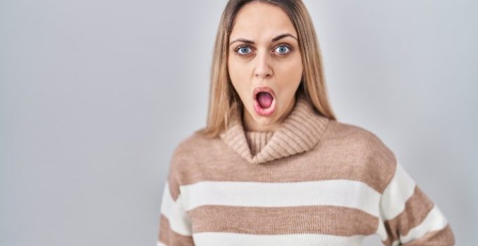 mujer rubia sorprendida y horrorizada