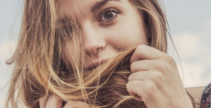 mujer inspecciona el color de un mechón de su pelo
