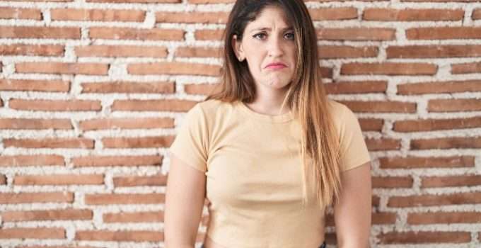 mujer descontenta con balayage en pelo oscuro