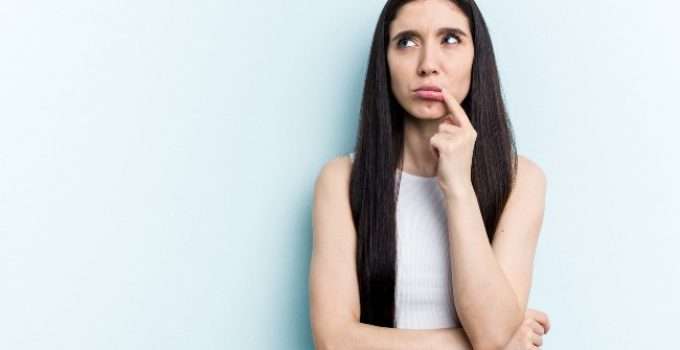mujer piensa y se lleva dedo a la boca