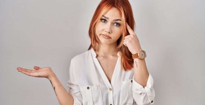 mujer se lleva dedo a la cabeza pensando