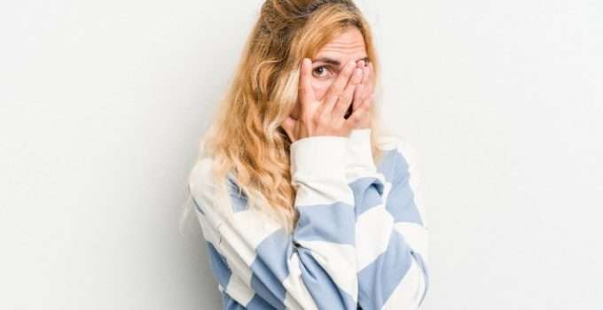 mujer se tapa la cara con miedo