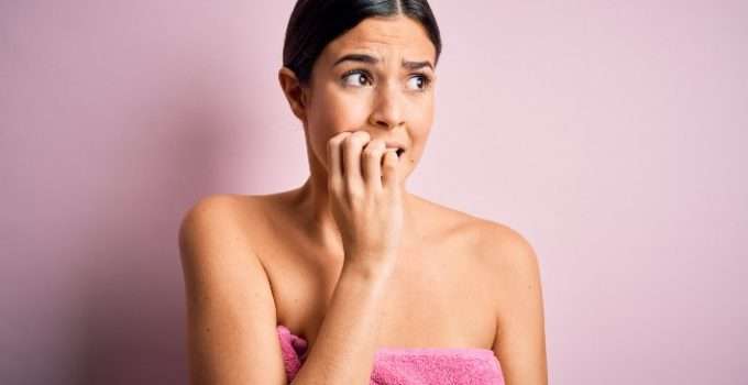 mujer se muerde las uñas mientras duda