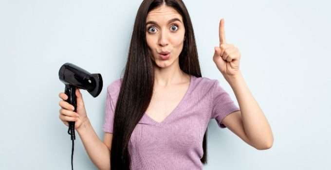 mujer sostiene secador de pelo