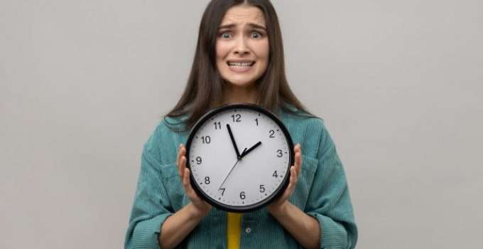mujer con reloj en la mano controla tiempo