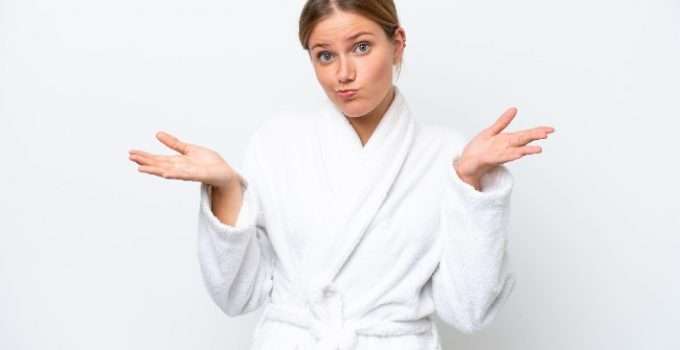 mujer en bata de baño con gesto de duda