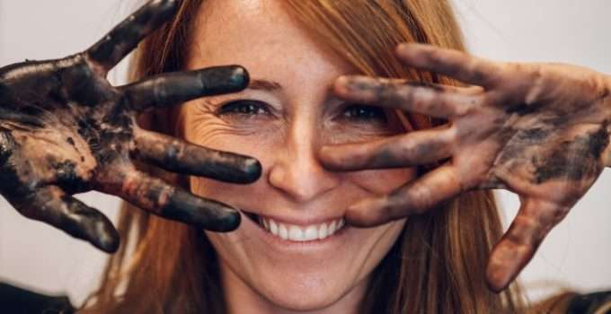 mujer muestra manos manchadas de tinte