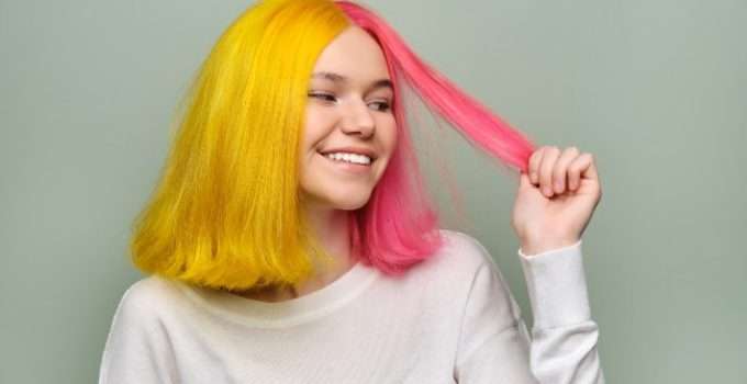 mujer mira su pelo teñido con tinte rosa y amarillo manic panic