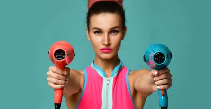 mujer con secadores en la mano y mechón rosa en el pelo