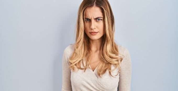 mujer teñida de rubio oscuro con cara de preocupada