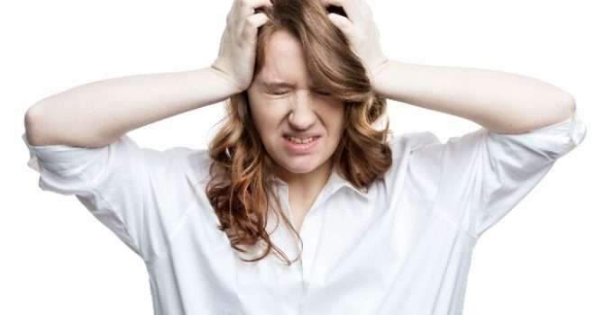 mujer de pelo marrón se agarra la cabeza después del tóner