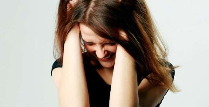 mujer de pelo marrón rojizo con gesto de desesperación