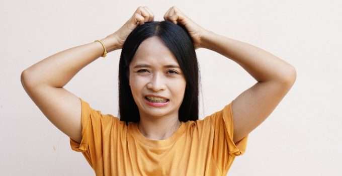 mujer de pelo lacio se rasca cuero cabelludo