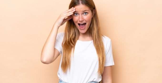 mujer con pelo anaranjado se lleva mano a la frente