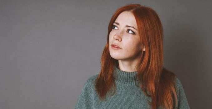 mujer de pelo rojo pensando en el color de su pelo