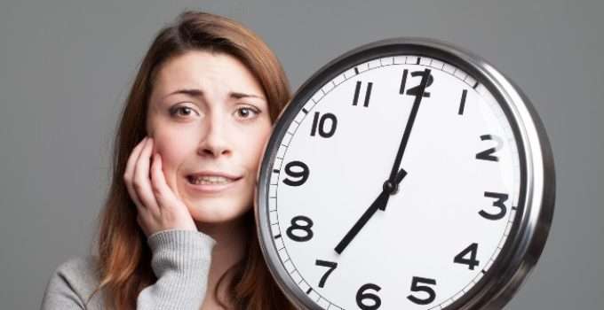 mujer con reloj grande en la mano piensa en reposo del tinte