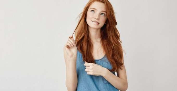 mujer toca su cabello teñido pensando en cuánto crece