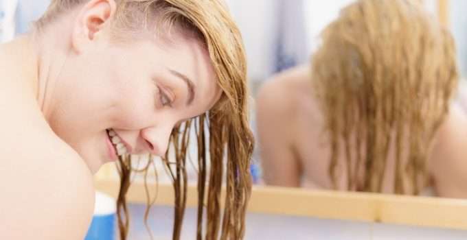 mujer enjuagando su pelo después de los reflejos