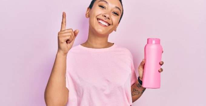 mujer con acondicionador en la mano pensando en mezclarlo con tinte