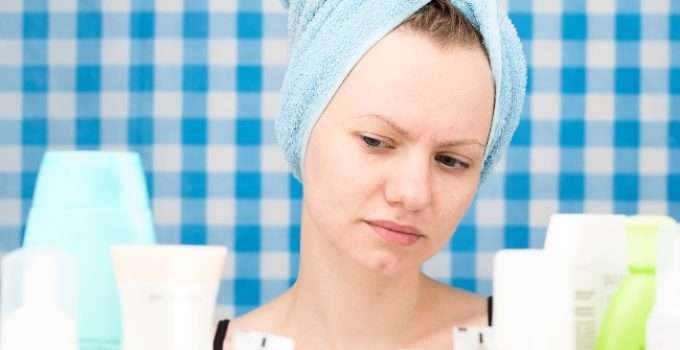 mujer en el baño mirando acondicionador para mezclar con tinte