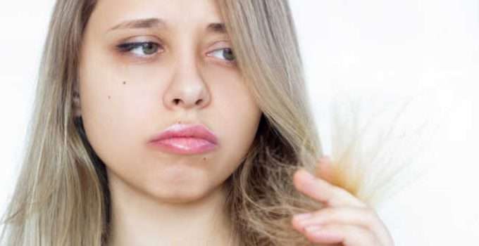 mujer mira el color desvanecido de su pelo después del primer lavado