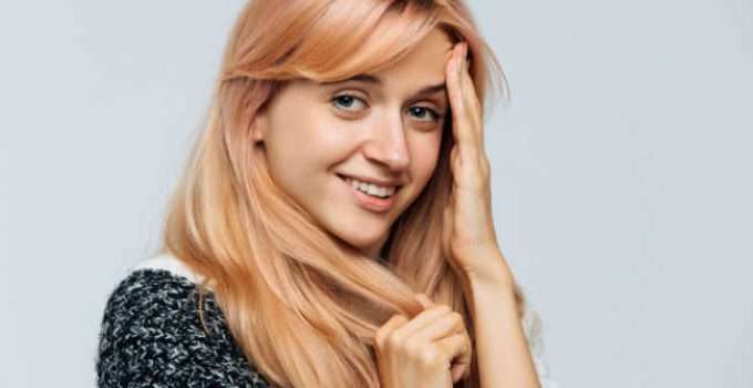 mujer con pelo rubio fresa quiere usar shampoo morado