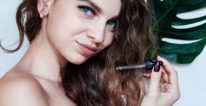 mujer sostiene gotero con aceite de argán