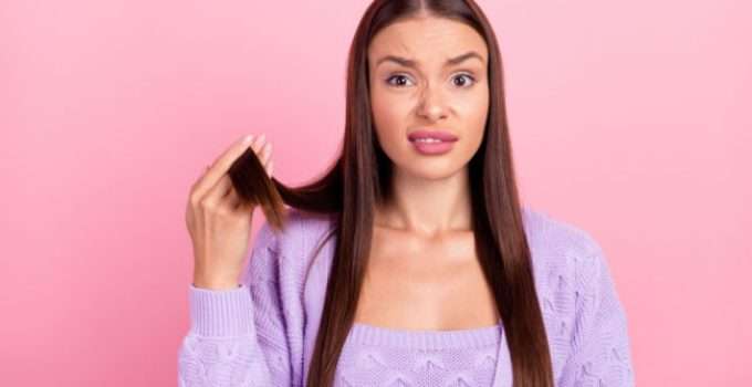 mujer sostiene en la mano un mechón de pelo con rebonding recién hecho