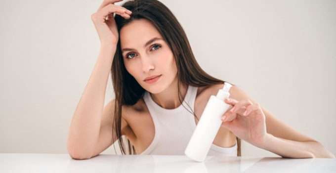 mujer con shampoo ácido en la mano