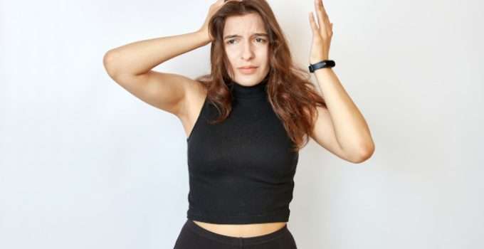 mujer se toca el pelo mientras duda