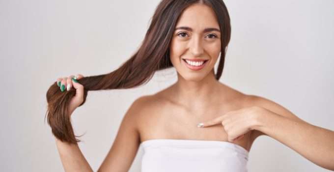 mujer feliz señala su pelo reparado con botox