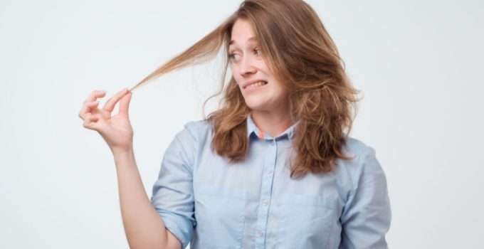 mujer mira su pelo chicloso para pintarlo