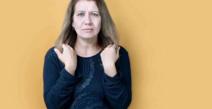 mujer tiene su cabello en las manos pensando en su crecimiento