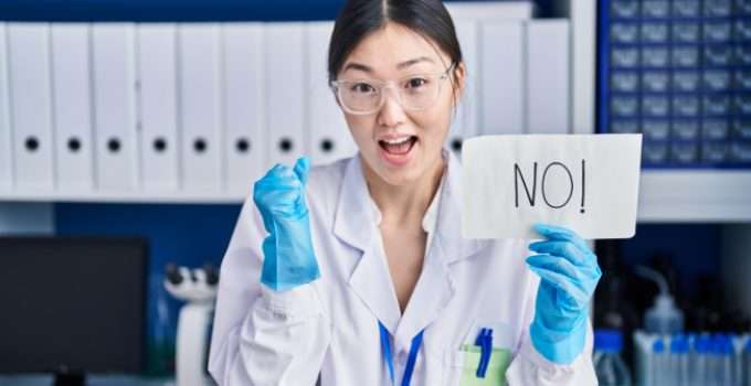 Una científica contenta con un cartel que dice NO! porque el alisado japonés no tiene formol