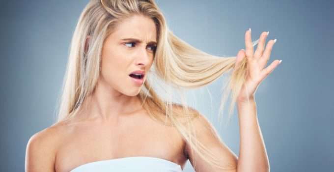 Muchacha mira su pelo decolorado pensando si puede volver a decolorarlo en tres días