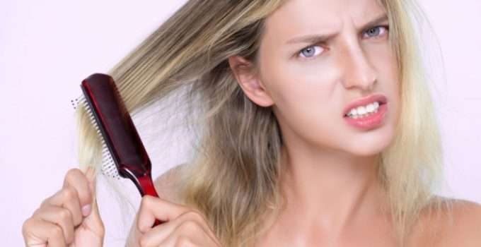 jovencita rubia sufre porque tiene su pelo dañado por la decoloración