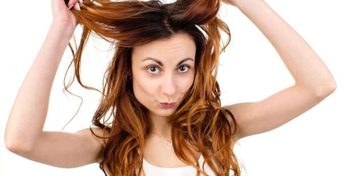 mujer sostiene mechones de pelo naranja