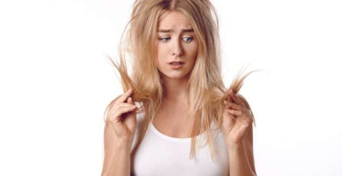 mujer mira su pelo naranja preocupada