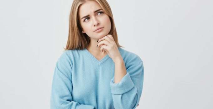 mujer rubia en postura pensativa