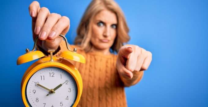 mujer de pelo rubio decolorado con reloj en la mano